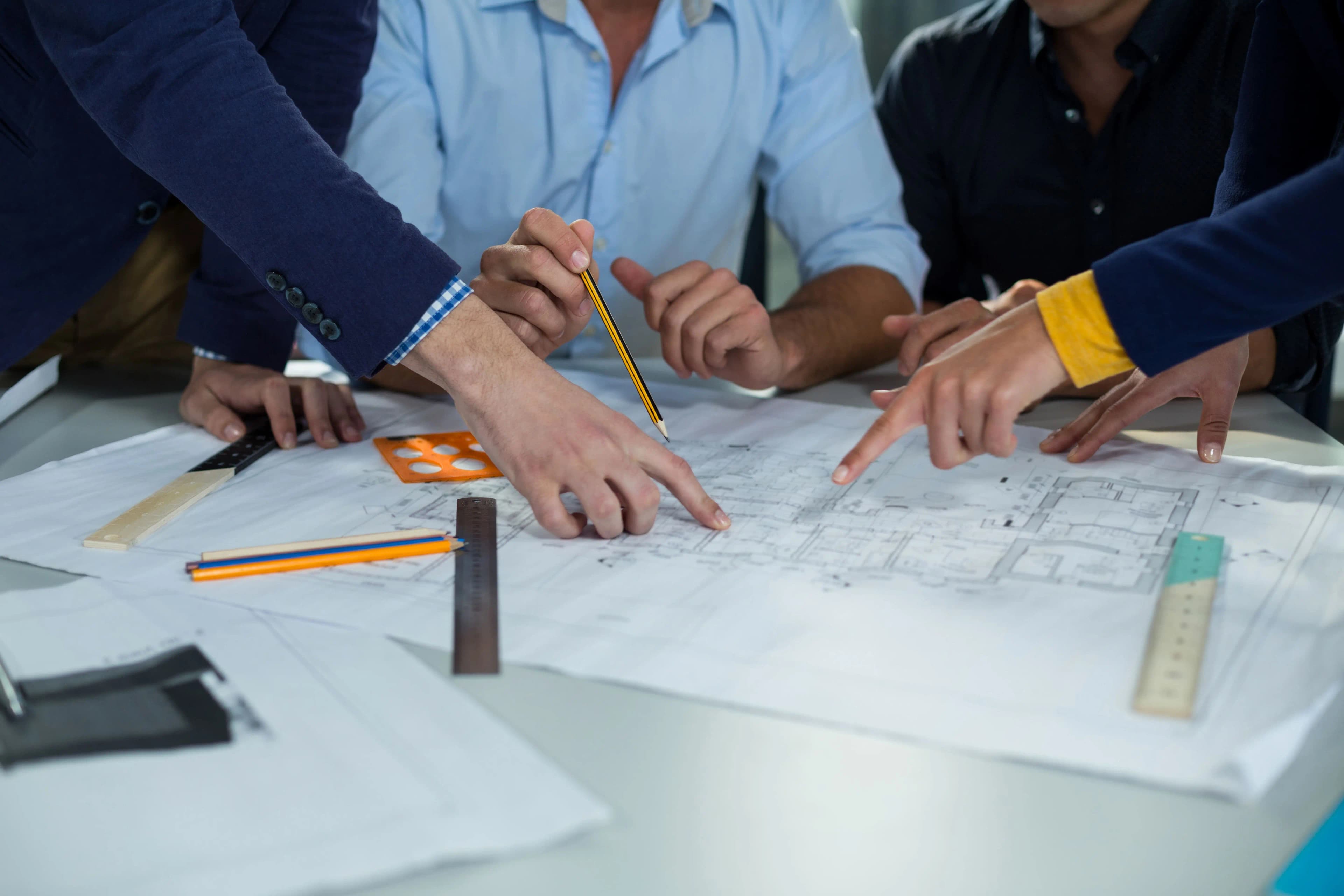 Equipo de ARTBACAR supervisando una obra de construcción a gran escala con planos y tecnología.
